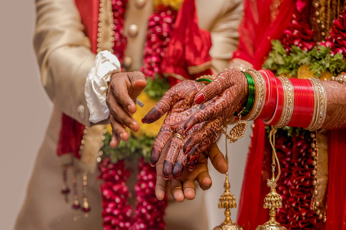 Traditional Indian Wedding Photo.
Concept of Ritual, Customs, Hindu Marriage, Vedic Marriage, Relationships, Husband Wife, Love Marriage, Arrange Marriage, Matrimony, Match making, Dowry marriage etc. depending on the vision of user.
Amazing photo of a traditional Indian wedding taking place wherein the bride and the groom are wearing ethnic Indian attire and are offering prasadam to fire god to receive blessings for their happy married life. Bride alongwith the dress is also wearing colorful bridal bangles and floral garland is worn by both bride and groom.